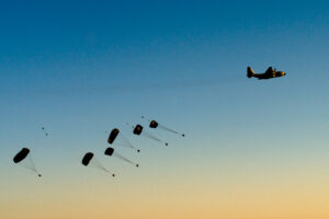 An Israeli Air Force C-130 Hercules "Karnaf" (Rhino) airdropping supplies at sunset.